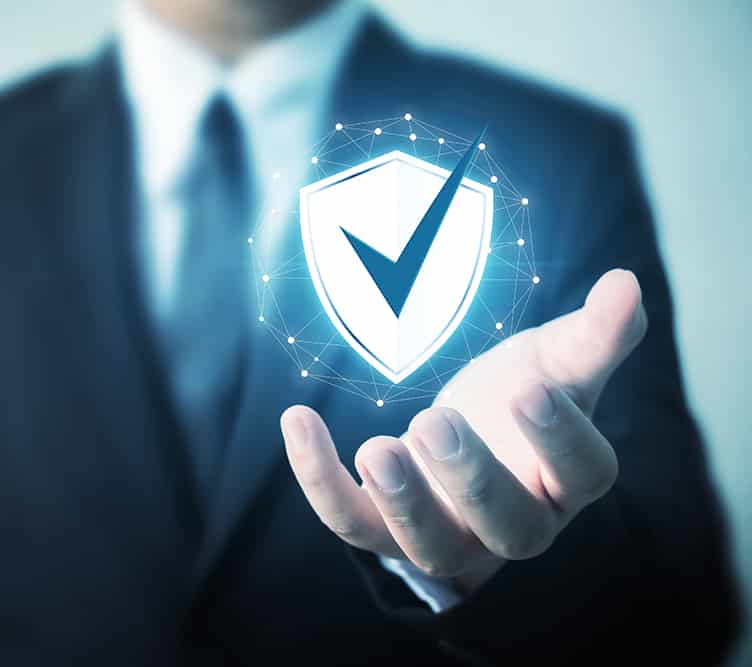 A business-person holding a shield with a checkmark that represents IT Security Services.