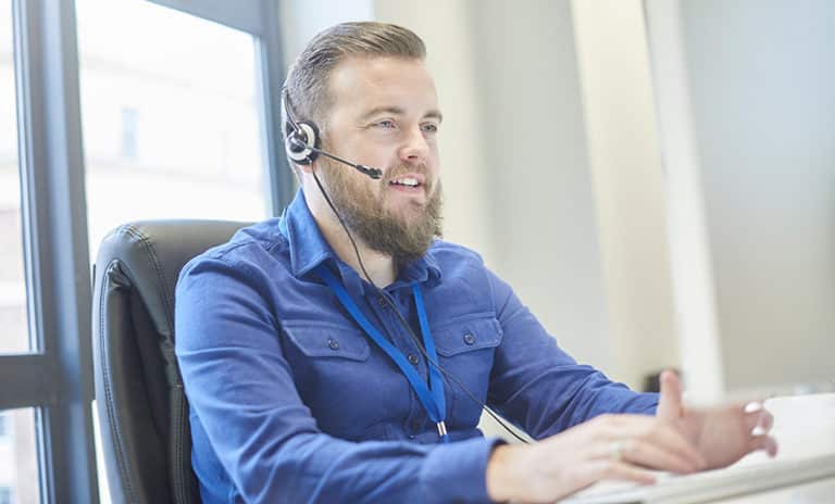 A local, US-based, help desk professional remotely troubleshoots and resolves an IT support ticket for a managed services customer over the phone.