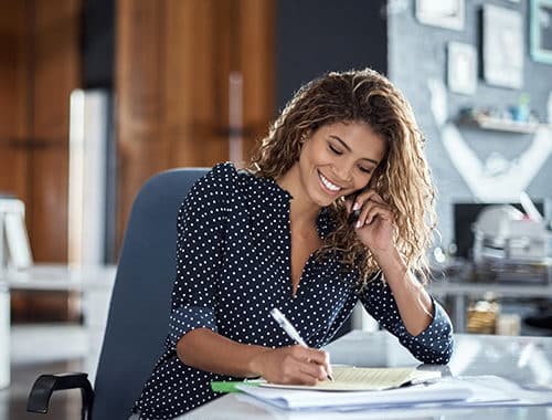 A cropped shot of an attractive business woman in your late twenties taking notes while using the VoIP softphone application on her cellphone to conduct business on the go.