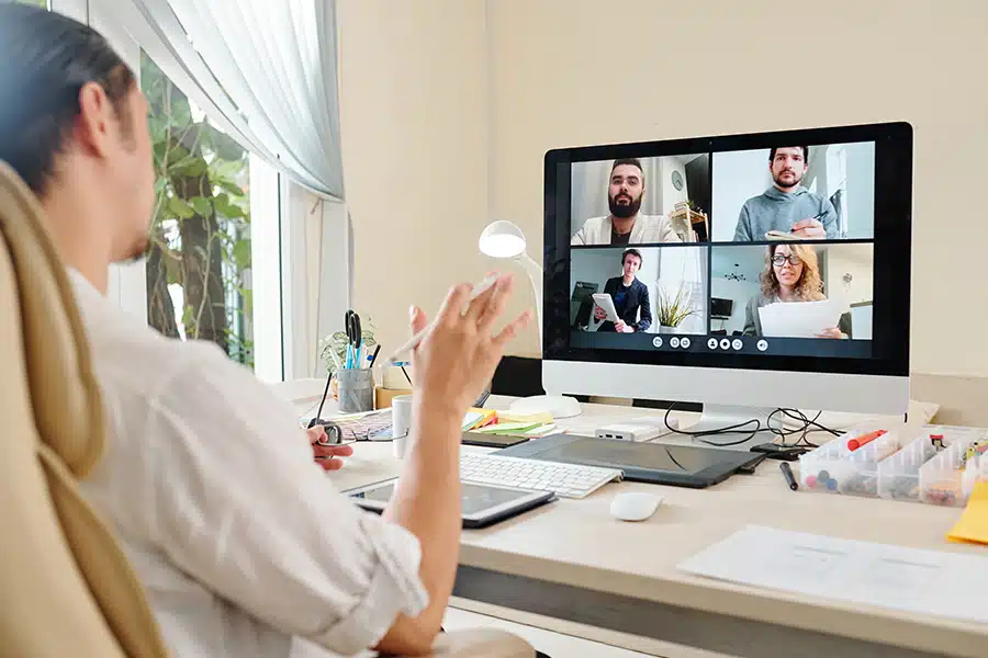 Someone looking at a Mac desktop, which is displaying a four-person videoconference