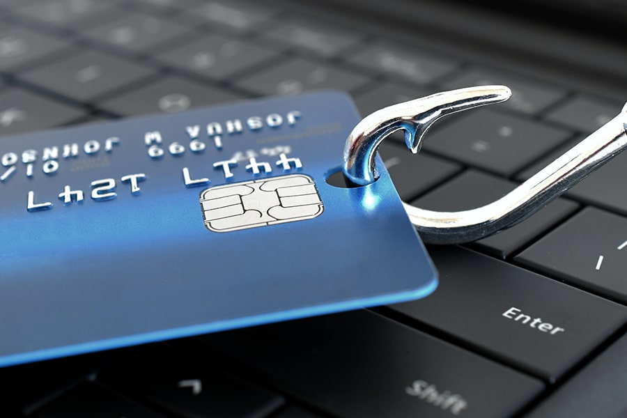 Phishing Definition: Someone who uses deception to gain credentials and access. This image shows a fishing hook going through a credit card.
